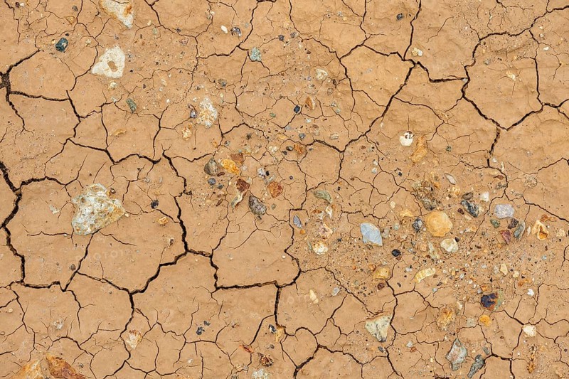 Cracks in the clay soil and coloured rhyolite rock
