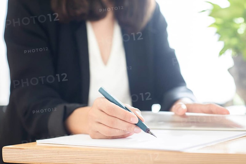 Woman signs contract with fountain pen