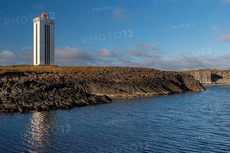 Lighthouse and coastal landscape with basalt formations and basalt cliff