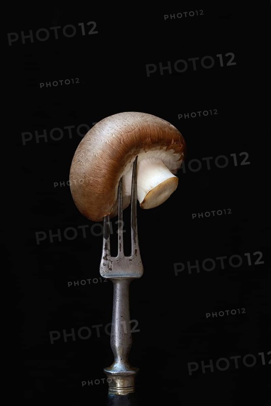 Brown cultivated mushroom on fork