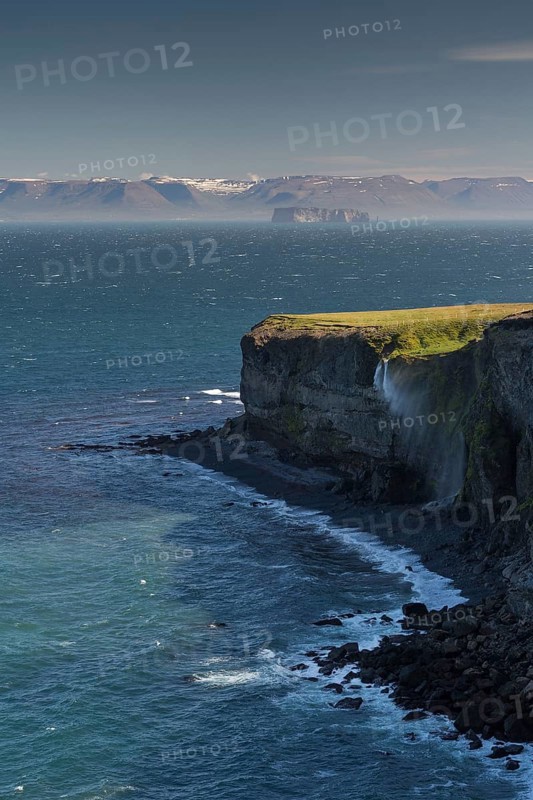 Waterfall falls over cliff and is blown away by wind