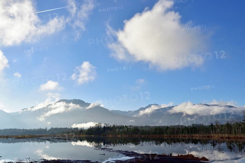 Sky with clouds and condensation trails over moor landscape