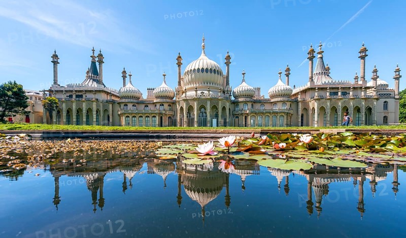 Royal Pavilion palace reflected in a pond with water lilies
