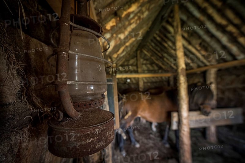 Old oil lamp in horse stable in original peat construction