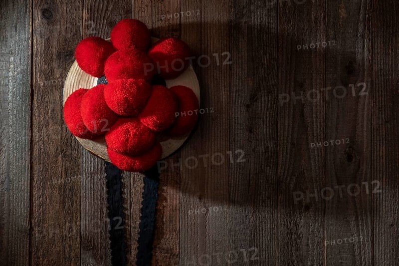 Original Black Forest Bollen hat in front of rustic wooden wall