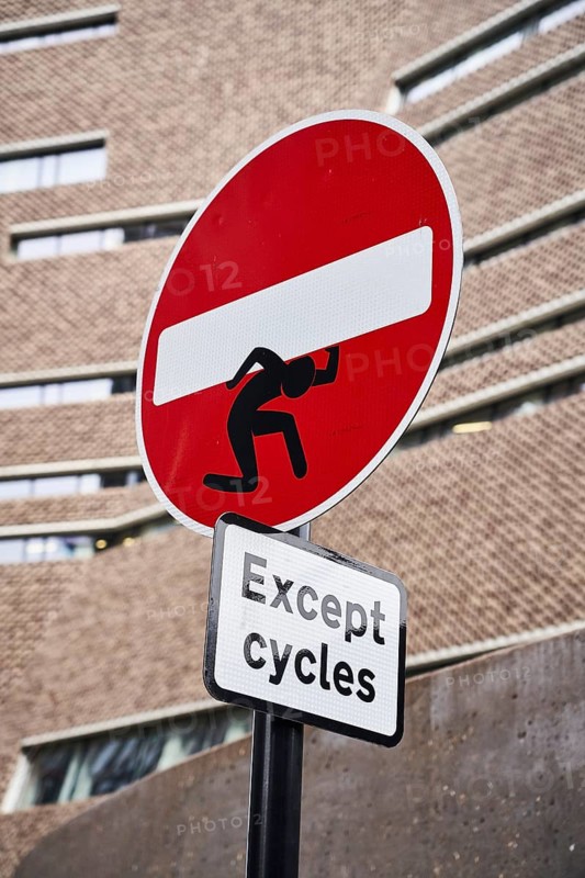 One-way street sign with street art manikin