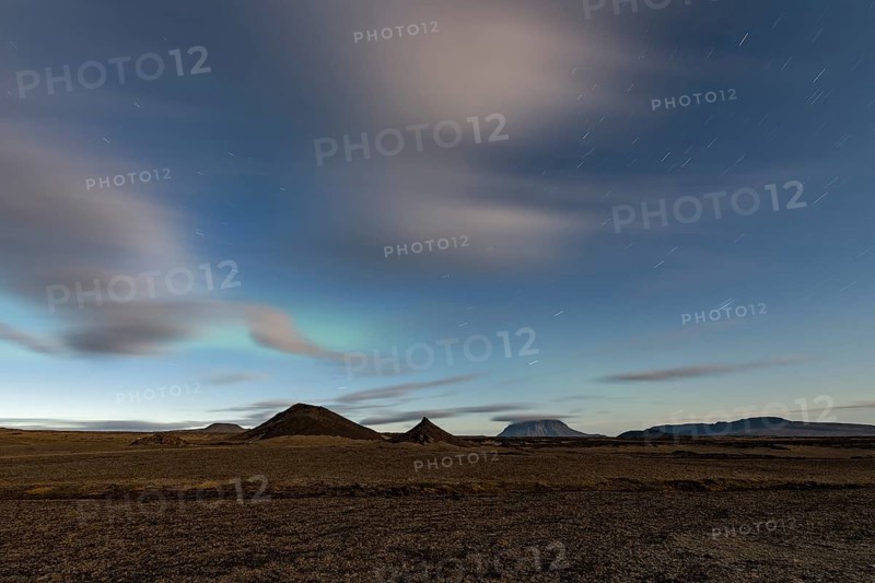 Faint northern lights (Aurora Borealis) and star trails