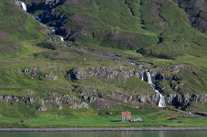 Remote farm in front of a waterfall