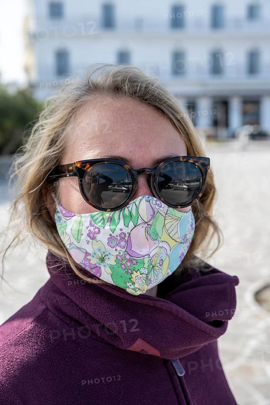 Young woman on vacation with mouth to nose covering
