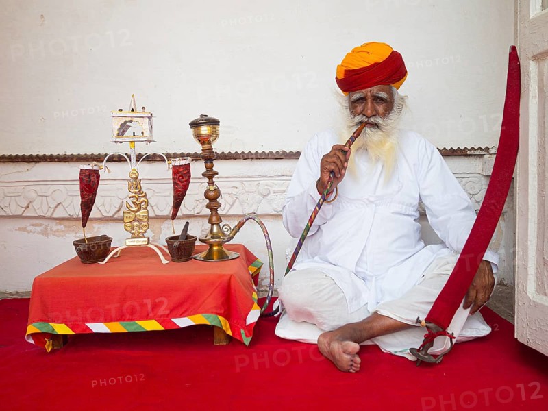 Elderly Indian man with turban smoke hookah