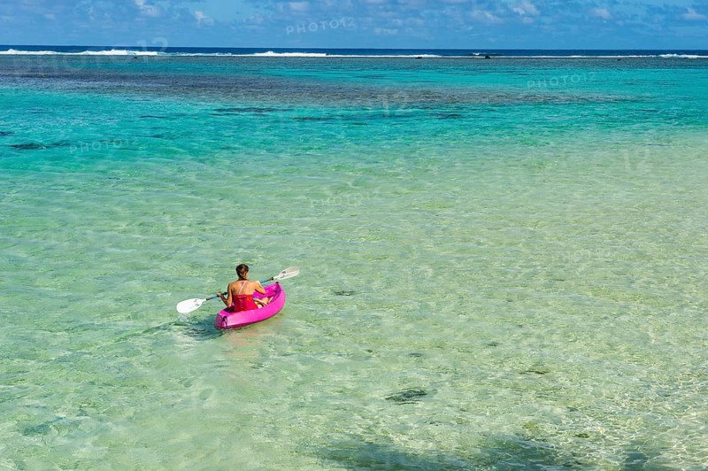 Woman kayaking in the turquoise waters of Rarotonga