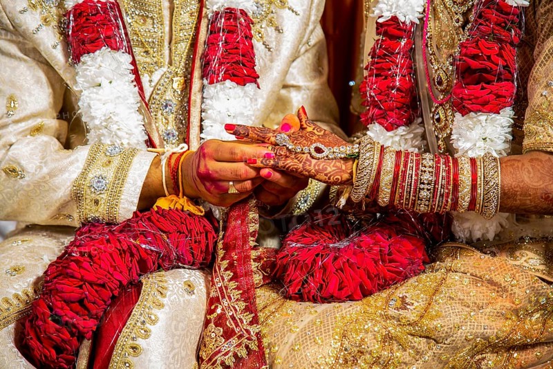 Indian groom passing wedding ring on his bride's finger on his wedding ceremony