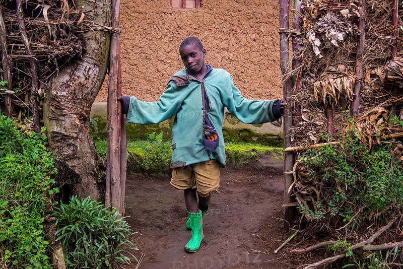 Young boy standing at the doorsteps of mud hut