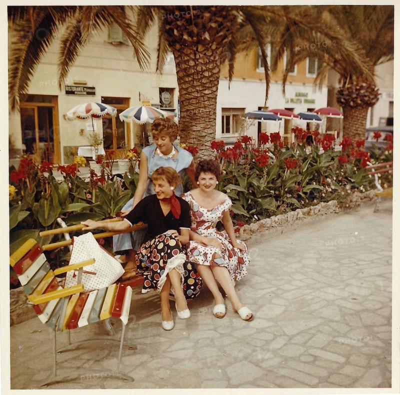 Three young German holidaymakers sitting on the beach promenade of Finale Ligure