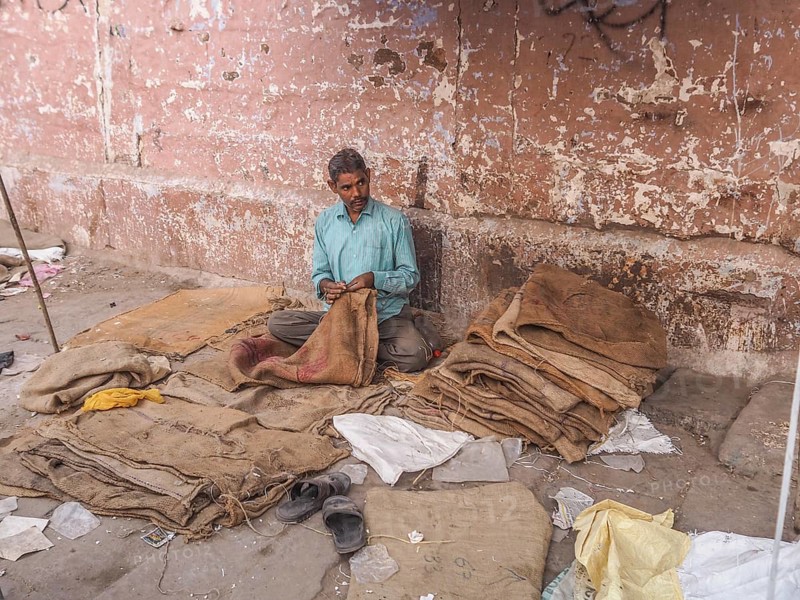 Worker sewing sacks