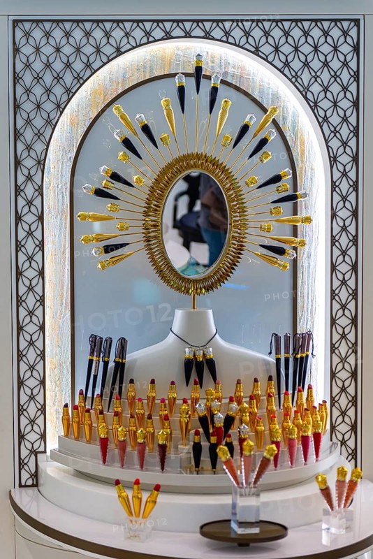 Golden mirror and lined up lipsticks on a display