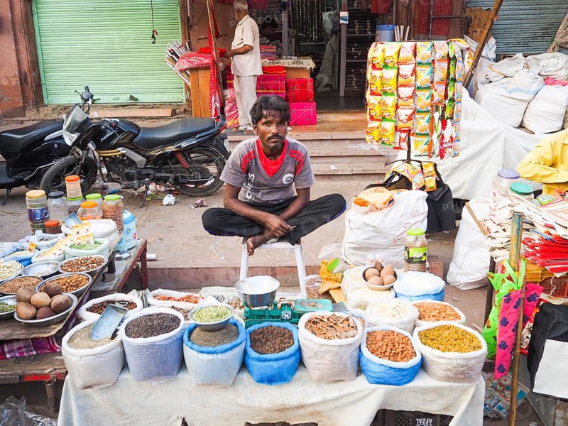 Vendor offering pulses at market stall
