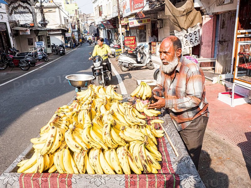 Vendor offering bananas at market stall