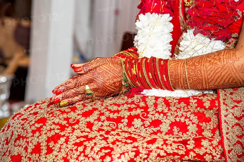 Traditional bridal jewelry and henna decoration on the hands of the bride during a religious ceremony at a Hindu wedding