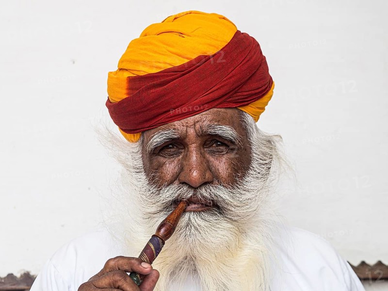 Elderly Indian man with turban smoke hookah