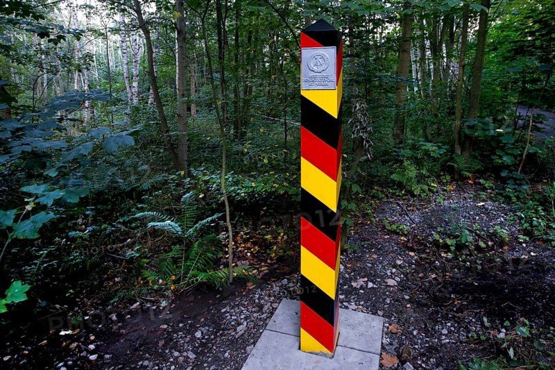 Border column with GDR coat of arms in the forest