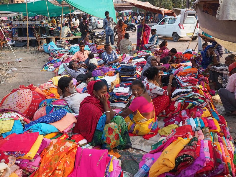 Vendor offering textiles at market stall
