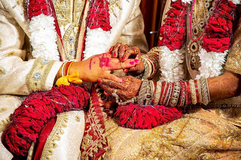 Indian bride passing wedding ring on her groom's finger on her wedding ceremony