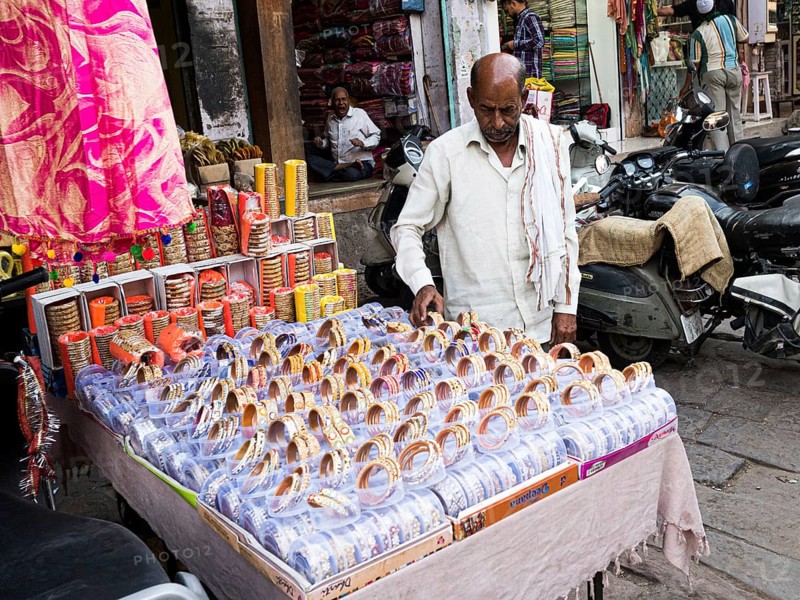 Vendor offering jewellery at market stall