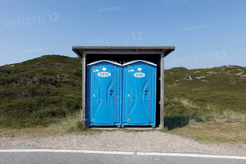 Two blue DIXI toilet stalls on a road