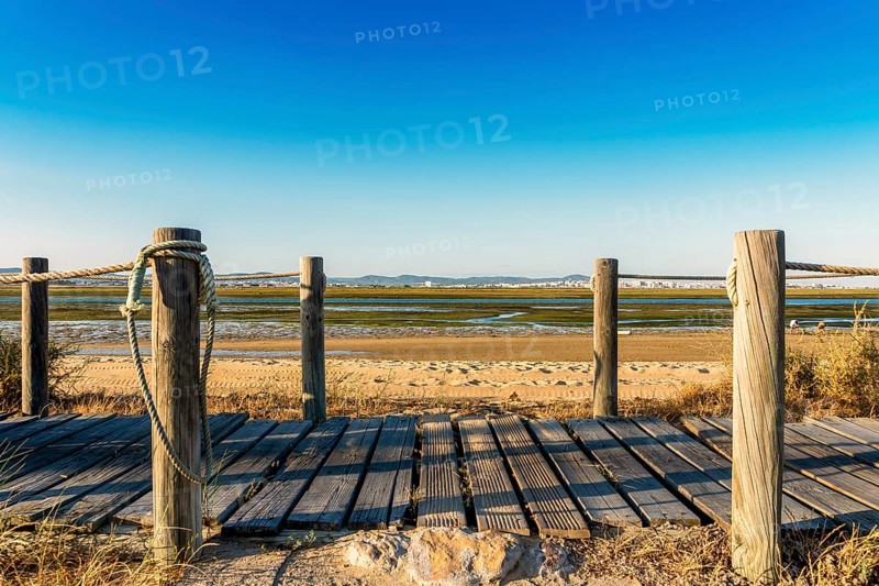 Wooden walkways with view on wetlands of Ria Formosa on Faro Beach Peninsula
