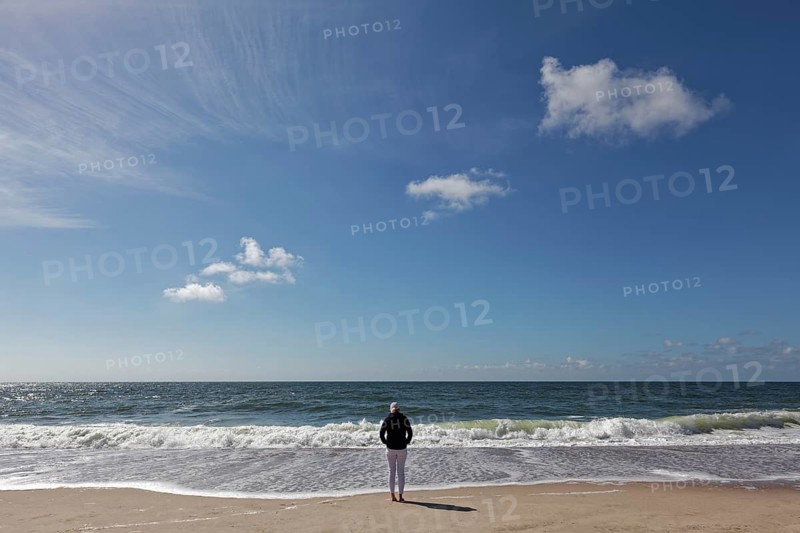 Single person with hoodie standing on the beach