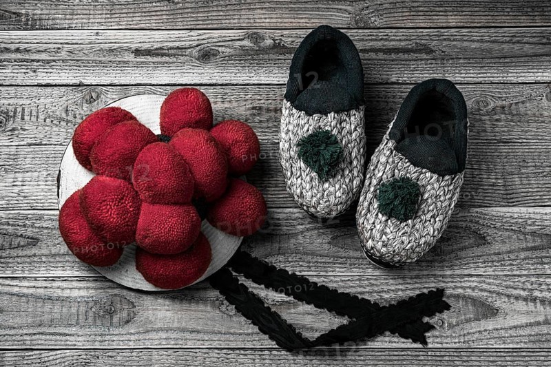 Original Black Forest Bollen hat with straw shoes on wooden background