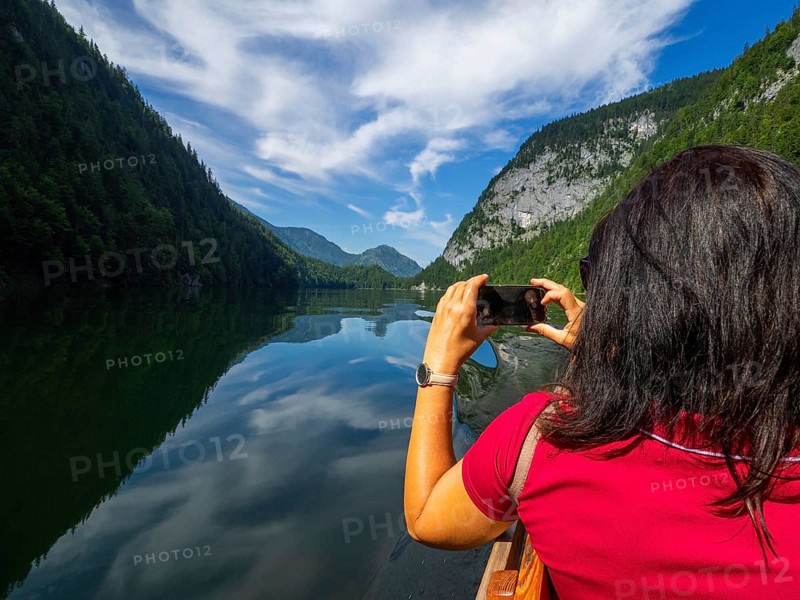 Tourist photographing Lake Toplitz from a traditional barge