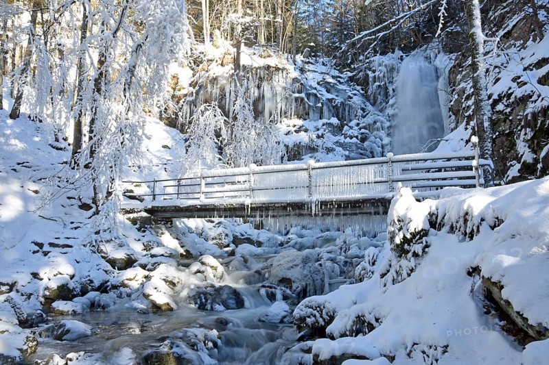 Bridge with icicles and icy waterfall