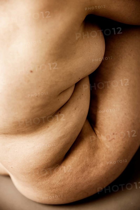 Wrinkled body of a seated naked