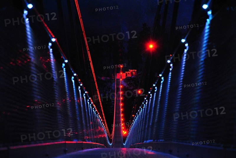 Pedestrian suspension bridge in the form of a rope bridge at night