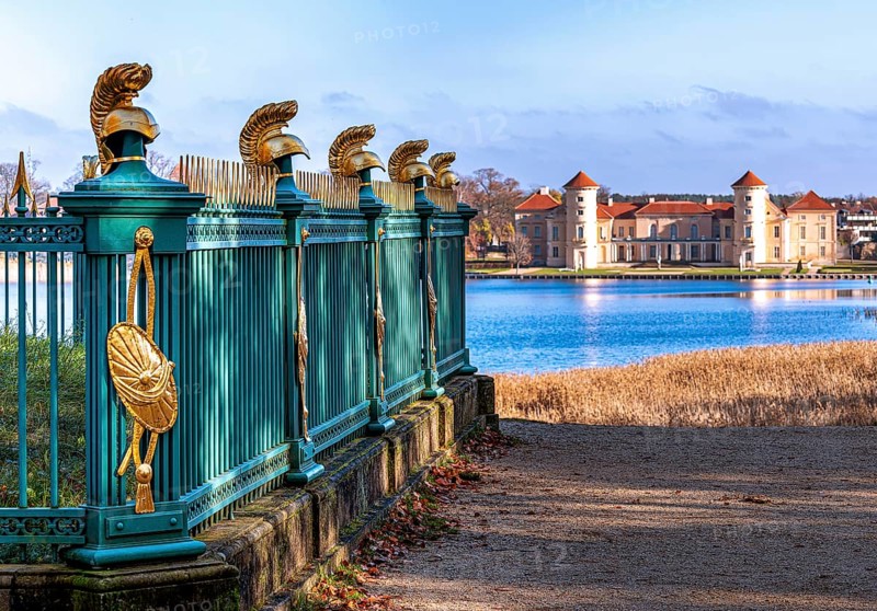 Restored fence with gold helmets at the Lake Grienerick obelisk in Rheinsberg