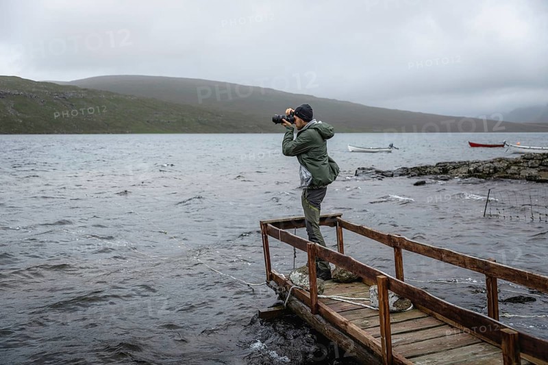 Hiker photographed on a wooden footbridge above Lake Leitisvatn