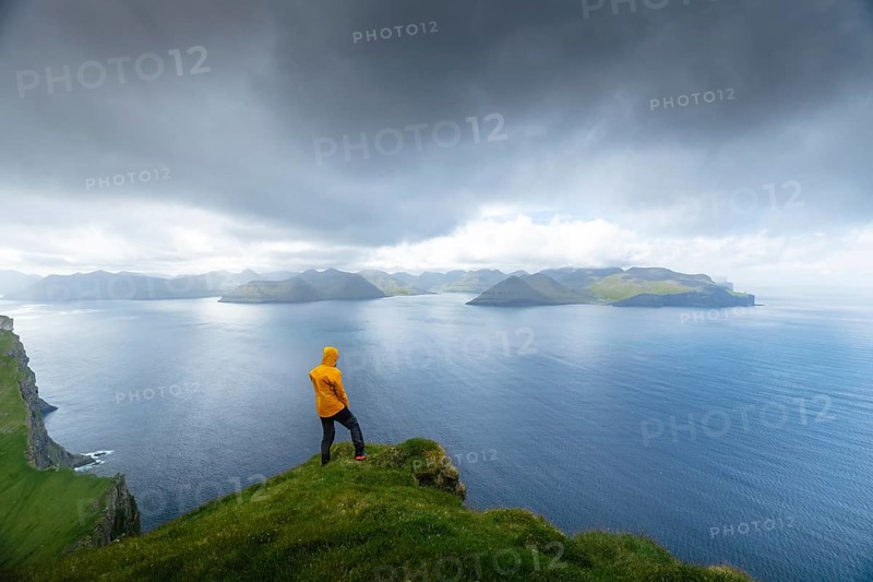 Person looking at the sea and the island of Eysturoy