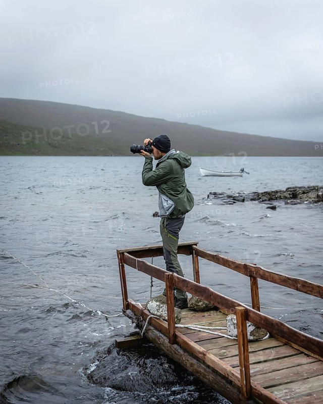 Hiker photographed on a wooden footbridge above Lake Leitisvatn