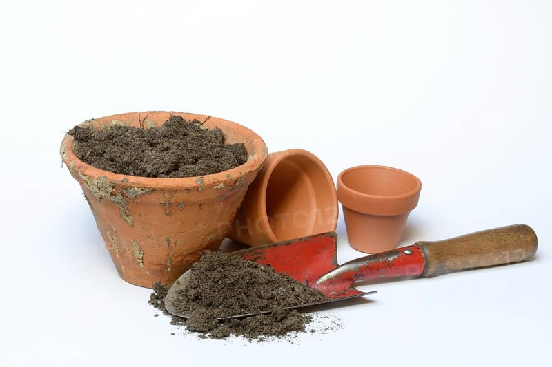 Clay pots with soil and garden shovel