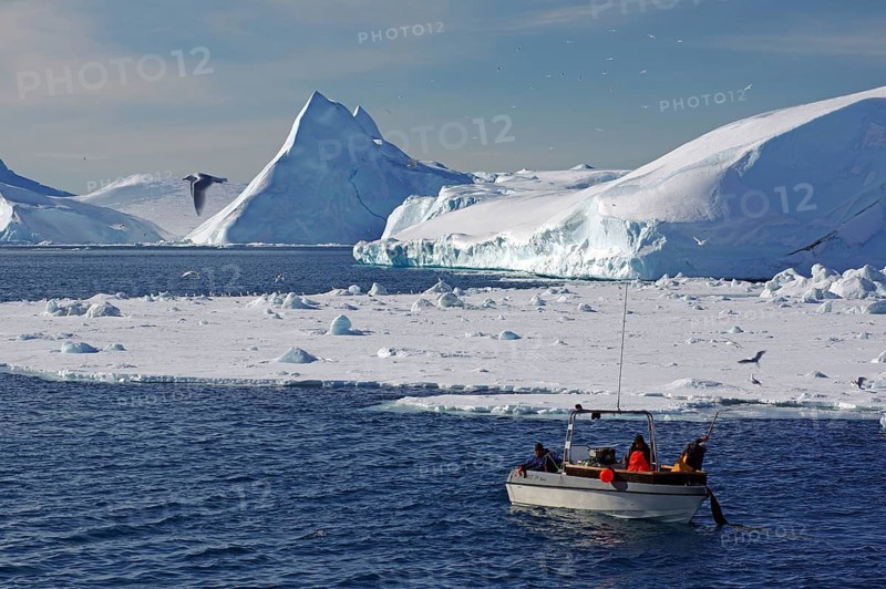 Fishing boat in front of icebergs