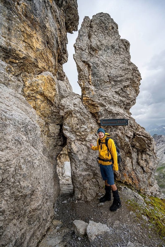 Hiker at rock formation with rock hole