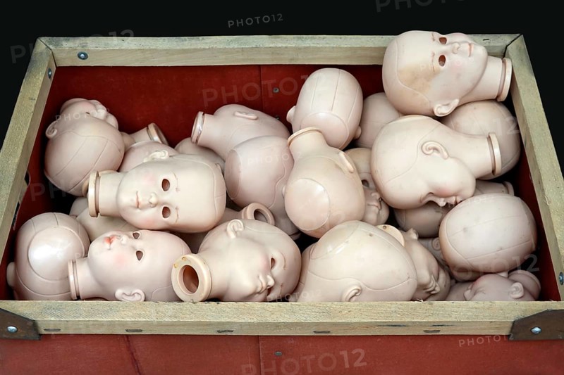 Doll heads without eyes in a box for a doll clinic