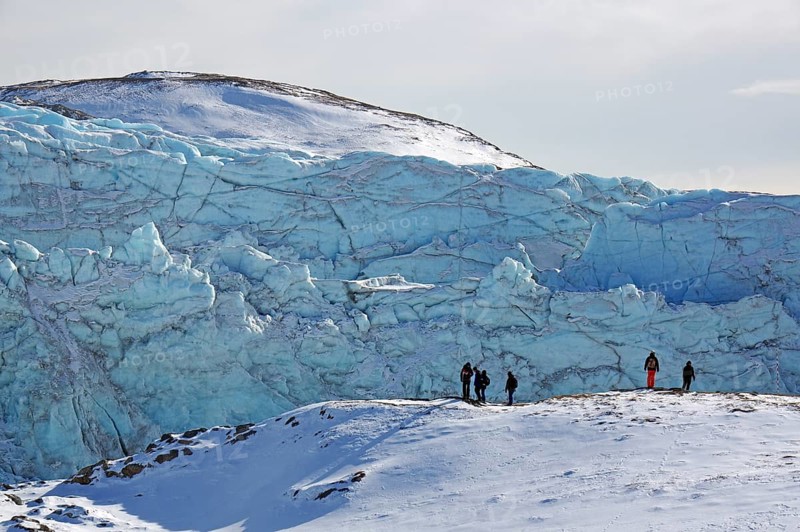 People in front of the break-off edge of the Russell Glacier