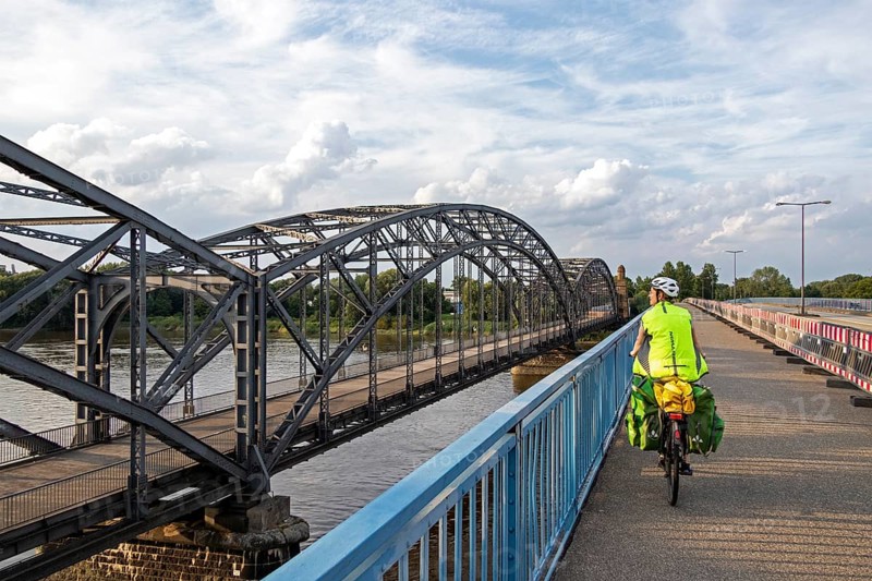 Woman riding her bicycle over bridge next to the Alte Harbruecker Elbbruecke