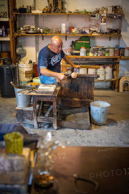 Master glassblower working hot glass