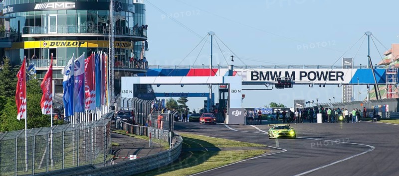 Race cars drive out of Nuerburgring race track pit lane