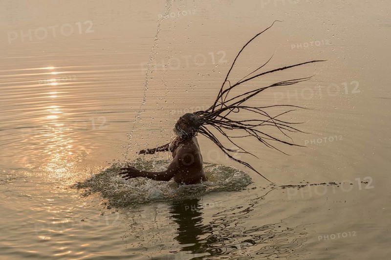 Rom Baba with water spraying from his flying dreadlocks in the river Ganges