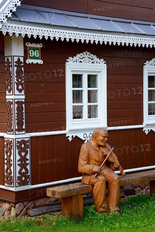 Wooden musician in front of house